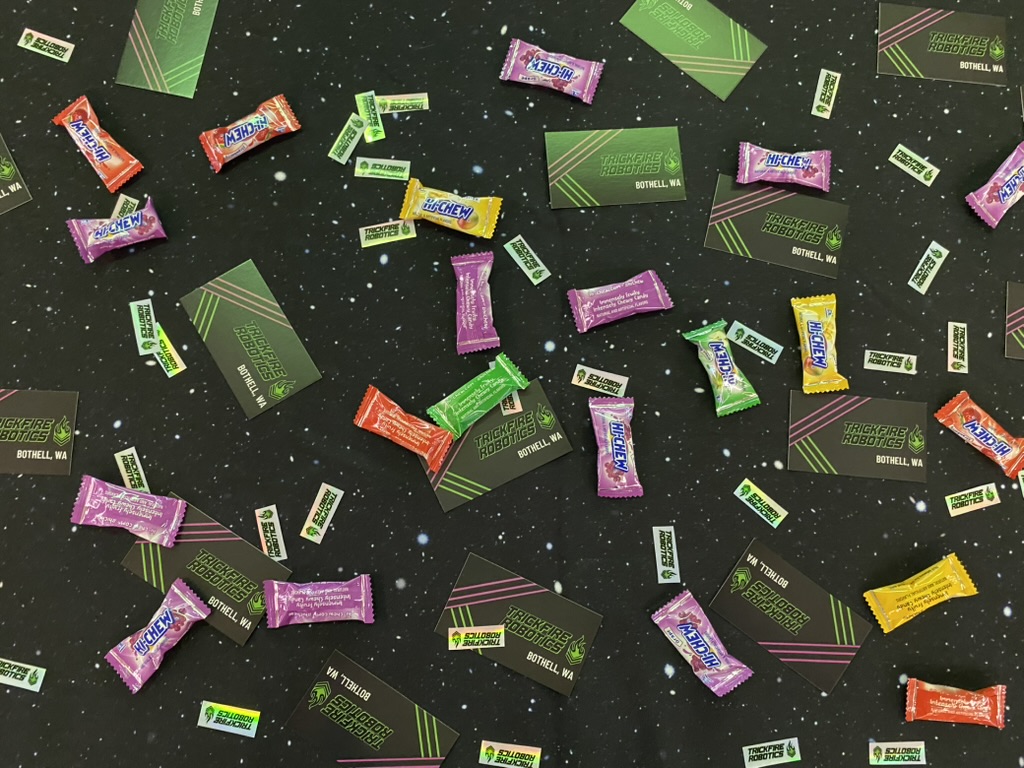 A starry table covered in business cards, stickers, and candy.