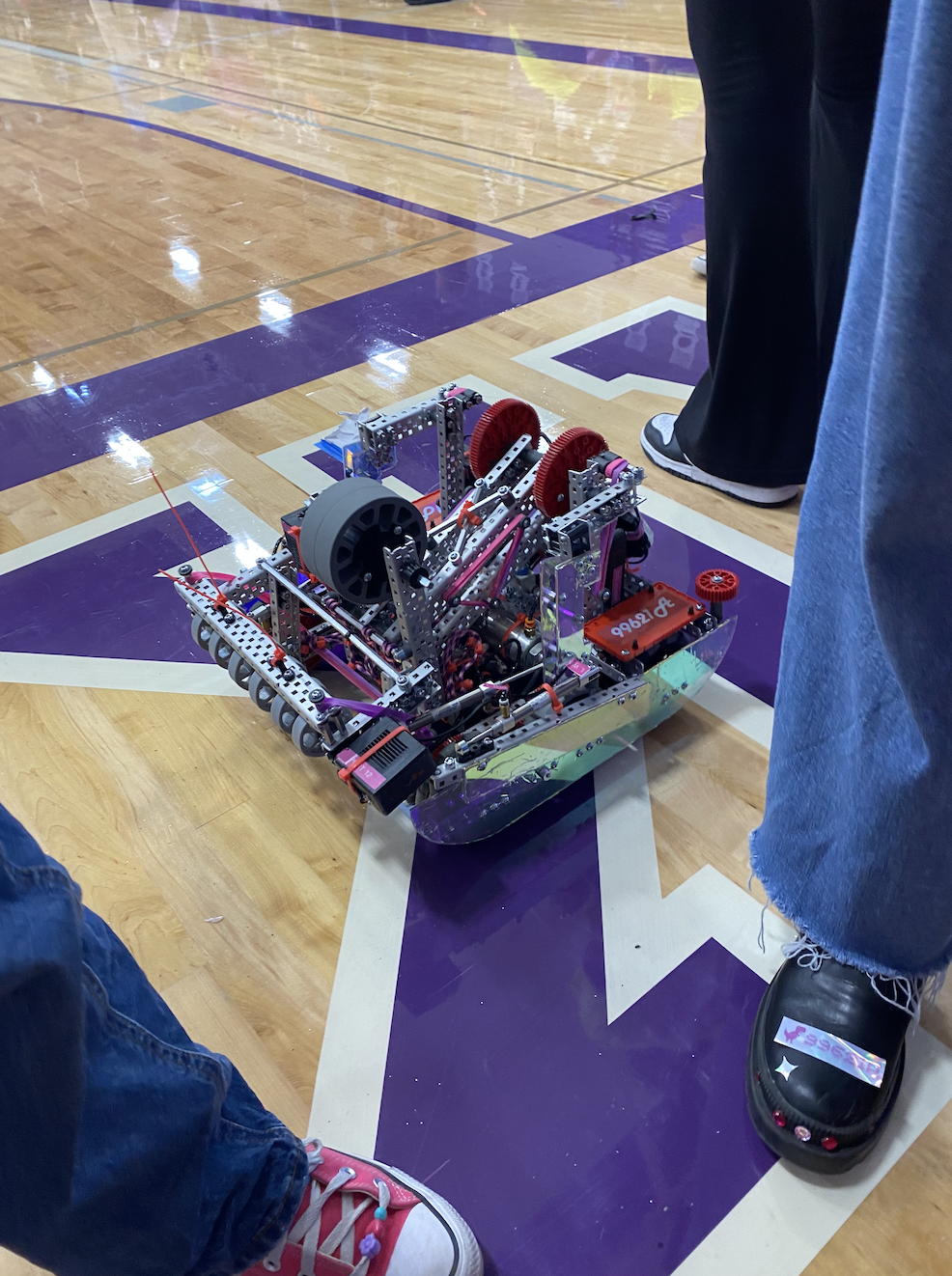 A pink and purple robot on a purple gymnasium floor.
